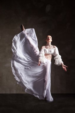 genç güzel dansçı gri arka plan üzerinde poz