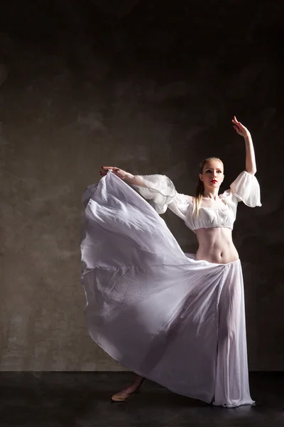 Junge schöne Tänzerin posiert auf grauem Hintergrund — Stockfoto