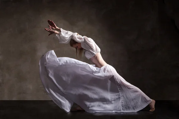 Mladá krásná tanečnice pózuje na šedém pozadí — Stock fotografie