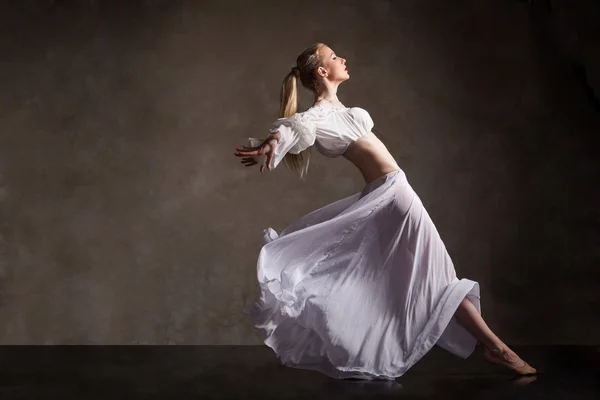 Junge schöne Tänzerin posiert auf grauem Hintergrund — Stockfoto
