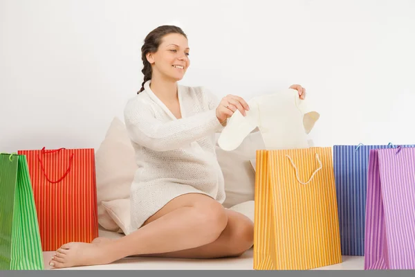 Donna incinta sorridente apertura shopping bag — Foto Stock