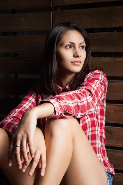 Mladá žena v kovbojské oblečení nad dřevo — Stock fotografie