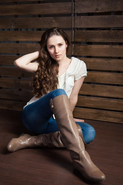 Jovem mulher em estilo cowboy roupas sobre a madeira — Fotografia de Stock