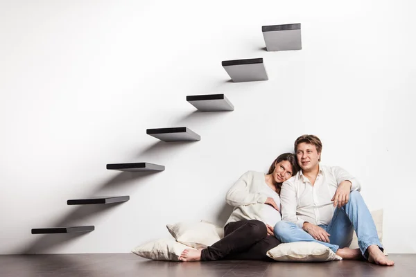 Couple at home sitting on stairs. Pregnancy — Stock Photo, Image