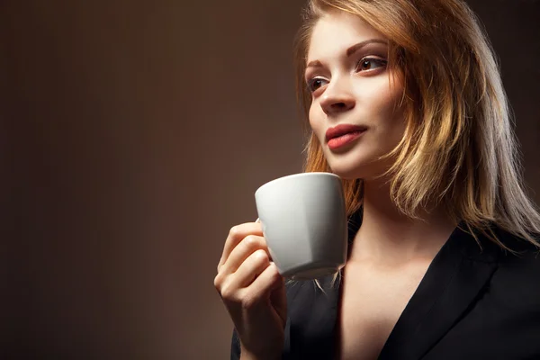 Красивая девушка пьет чай или кофе — стоковое фото