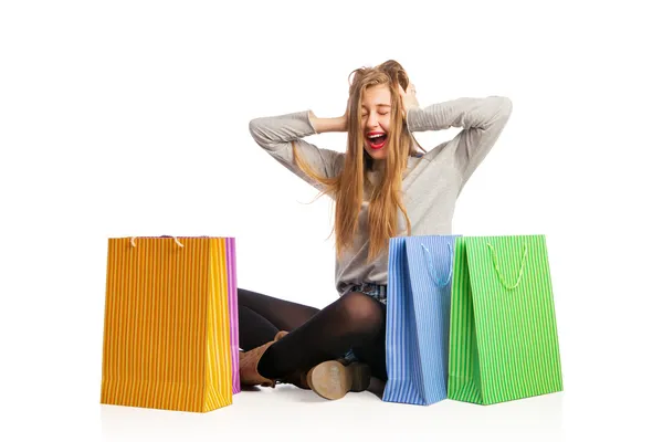 Mujer emocionada sentada entre coloridas bolsas de compras — Foto de Stock