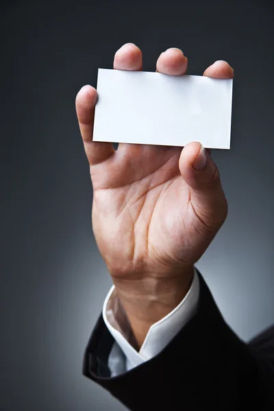 Business man show card on dark grey — Stock Photo, Image