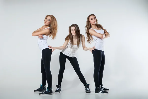 Drie moderne stijl dansers vrouw over grijs — Stockfoto