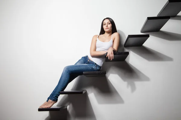 Sexy mujer sentado en escaleras sobre gris — Foto de Stock