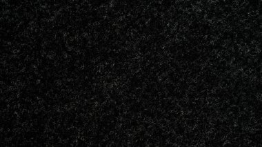 Closeup of seamlessly black and grey carpeting for background and design.