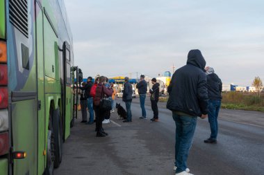 Bachevsk 'te. Ukrayna. Ekim 2021: Ukrayna sınırında seyahat bekleyen uluslararası bir otobüsün yolcuları