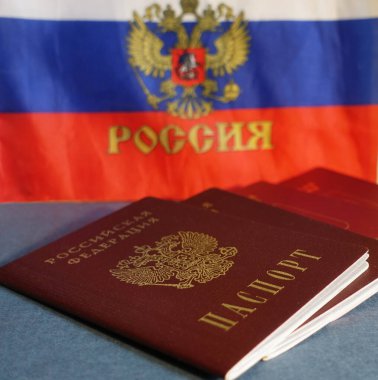Rusya Federasyonu pasaportları Rus bayrağının arka planında yatıyor.
