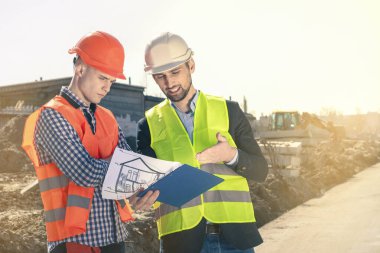 İnşaat müfettişi inşaat alanındaki beton pompaların dökülmesini denetliyor. Arazi girişimi inşaat çalışmalarının grafiksel temsili.