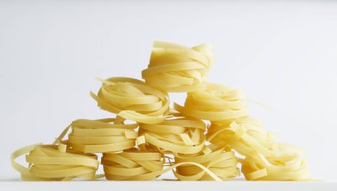 Durum buğdaylı fettucine makarna, çocuk küplerinden yapılmış bir ev şeklinde beyaz bir tabağa serilmiştir. Gün ışığı. Yakın plan.