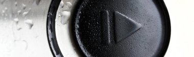 Yuvarlak düğme, modern bir aletin cilalanmış metal yüzeyindeki nem damlalarında duraksamaya neden olur. Modern teknolojide ilerleme kavramı. Makro. Web afişi. Yakın plan.