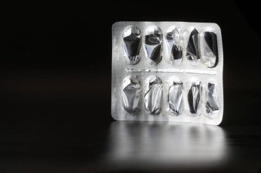 Boş alüminyum ilaç ambalajı. Aşırı doz ve zehirlenme. Siyah arka plan. Yakın plan.