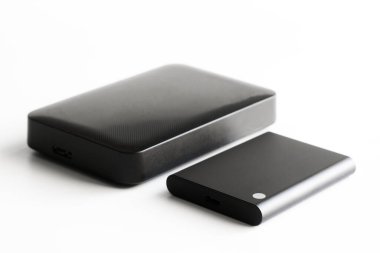 Dış SSD ve dış HDD boyutlarının karşılaştırılması. Bilgisayar dijital çevresi. Veri deposu. Seçici odaklanma. Beyaz arkaplan