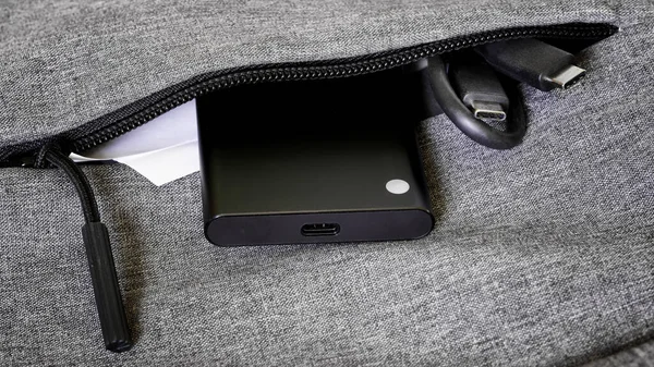 小さな外付けポータブルSsdは Usb Type Cケーブルの横にあるバッグ バックパック またはジャケットのポケットにあります ソリッドステートドライブ 現代の技術やガジェットの概念 — ストック写真