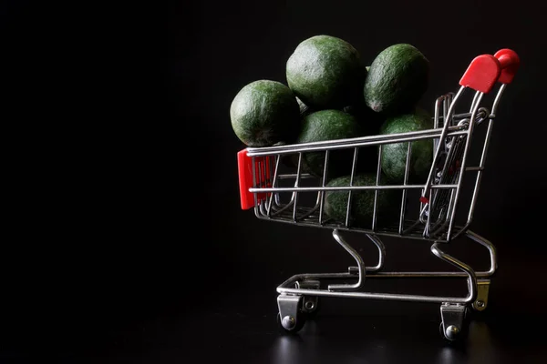 배경의 슈퍼마켓의 트롤리에서 녹색의 열매가 나온다 슈퍼마켓 식료품 점에서 과일을 — 스톡 사진