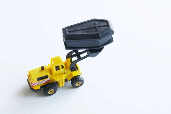 Жовтий Іграшковий Навантажувач Тримає Чорну Іграшкову Труну Відрі Концепція Ексгумаційної — стокове фото