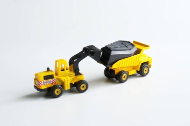 Sarı oyuncak forklift oyuncak tabutu kamyona yüklüyor. Mezardan çıkarma ve adli inceleme kavramı. Mezarlığın yeri ve ıslah konsepti. Bir yazı için boş yer. Yakın plan.