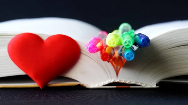 Many Multi Colored Pens Open Book Red Heart Dark Background — Stock Photo, Image