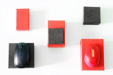 Kırmızı ve siyah bilgisayar faresi ve beyaz arka planda kırmızı ve siyah hediye kutuları. Oyuncular için bir bilgisayar dükkanı penceresinin minimalist tasarımına bir örnek. Gün ışığı