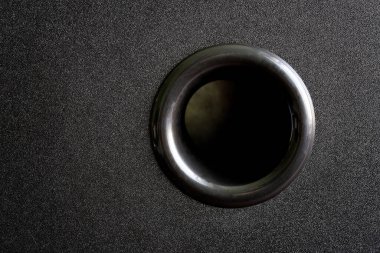 Ses hoparlörünün siyah ahşap kutusunda subwoofer bas refleks deliği var. Yakın plan.