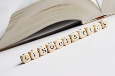 Dil bilimi açık bir kitabın yanında. Dil ve edebiyat tarihi üzerine dil ve bilim eğitimi kavramı. İnsani bilimler. Beyaz arka plan. Seçici odaklanma. Makro