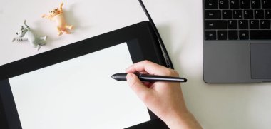 Kadın ekranında grafiksel tablet olan komik oyuncak kediler çiziyor. Beyaz arka plan. Yazı veya çizim için boş alan. Yüzü yok. Yakın plan.