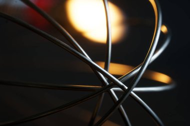 Metal çırpma parçası. Denizaltı mikserinin detayları. Yangın ya da şöminenin sarı röfleleri. Siyah arka plan. Soyutlama. Seçici odaklanma. Makro