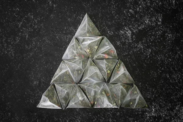 Set Tea Bags Pyramids Green Flavored Tea Dark Textured Surface — Stock Photo, Image