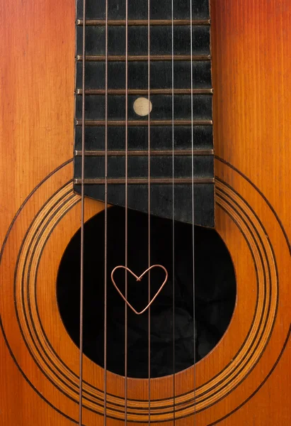 A heart lies on strings the guitar