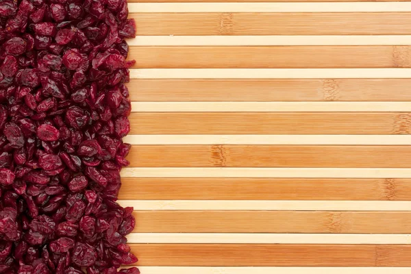 Dried cranberries lying on a bamboo mat — Stock Photo, Image