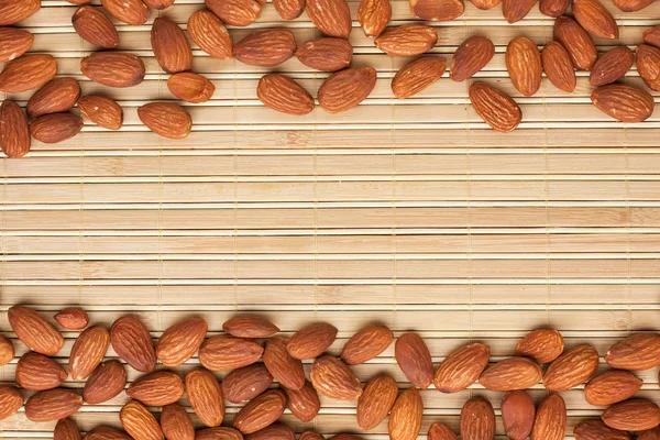 Almond lies on the a bamboo mat — Stock Photo, Image