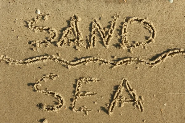 Word of sand, sea written on the sand — Stock Photo, Image