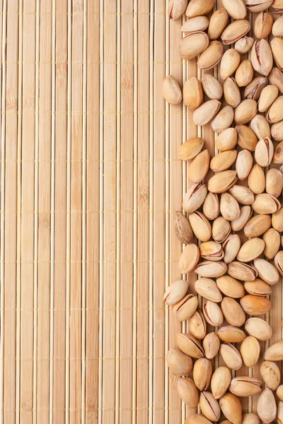 Pistachios lying on a bamboo mat — Stock Photo, Image