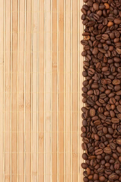 Grãos de café deitado em uma esteira de bambu — Fotografia de Stock