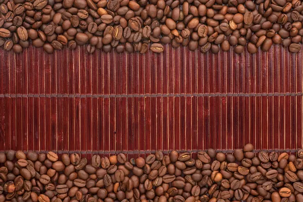 Grãos de café deitado em uma esteira de bambu — Fotografia de Stock