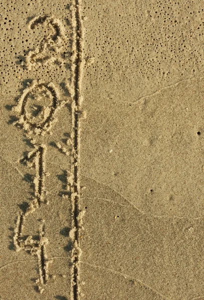 Word 2014 written by in the sand — Stock Photo, Image