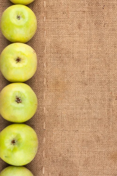 Green apples lie on sackcloth — Stock Photo, Image