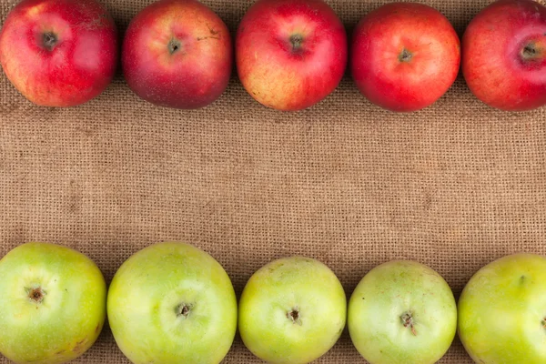 Green and red apples lie on sackcloth — Stock Photo, Image