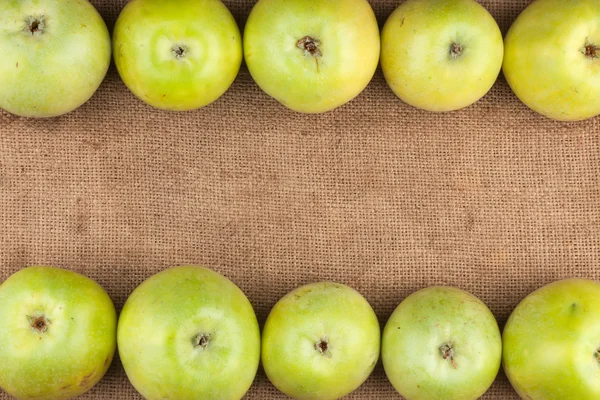 Green apples lie on sackcloth — Stock Photo, Image