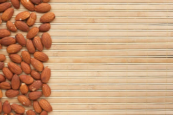 Almond is on a bamboo mat — Stock Photo, Image