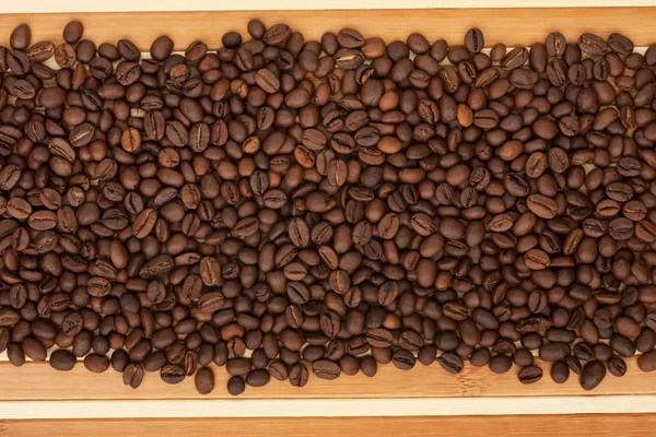 Kaffeebohnen liegen auf einer Bambusmatte — Stockfoto