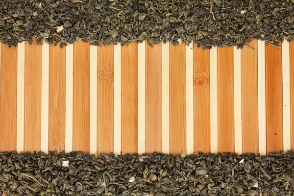 Dried green tea on a bamboo mat — Stock Photo, Image