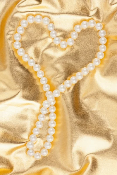 Symbolic heart on a gold fabric — Stock Photo, Image