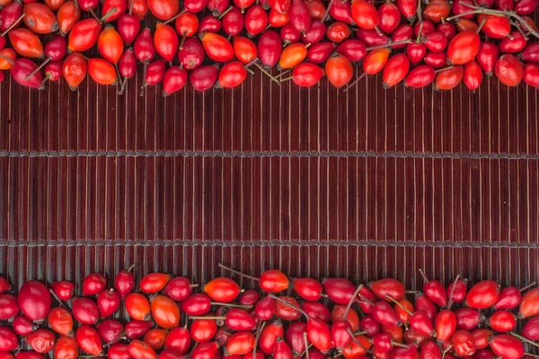 Rosehip on a dark bamboo mat — Stock Photo, Image