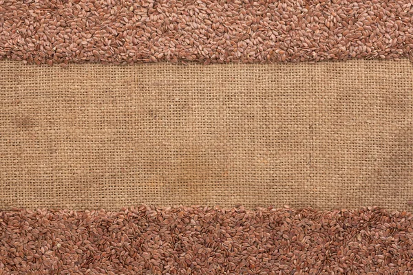 Flax seeds lies on sackcloth — Stock Photo, Image