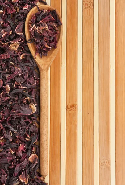 Spoon with dried hibiscus on a bamboo mat — Stock Photo, Image